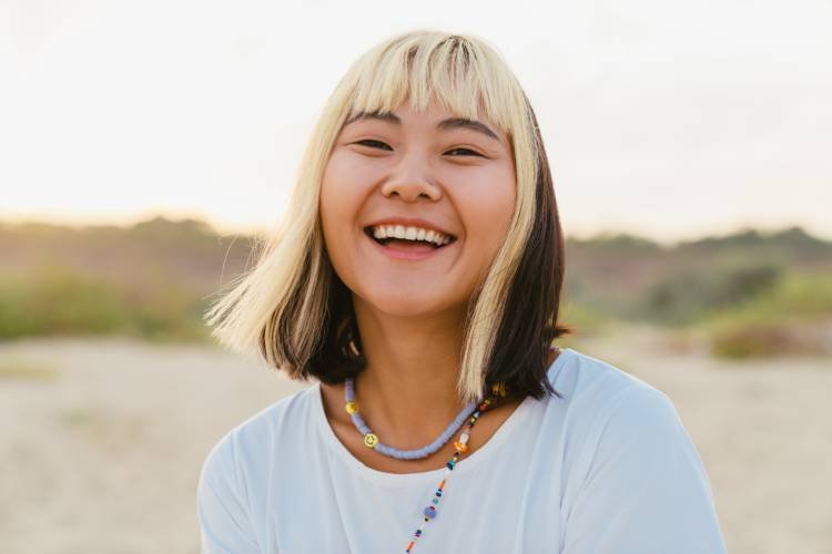 young-asian-woman-laughing-while-walking-on-beach-2025-02-16-03-59-50-utc